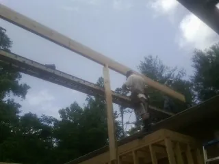 Carpenter setting a ridge beam over a new addition frame — Ice Dam Removal by Roofing Brothers in Prairieburg