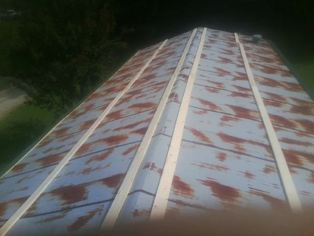 Rusted metal roof panels with new wood purlins before replacement — Storm Damage Roof Repair in Prairieburg by Roofing Brothers