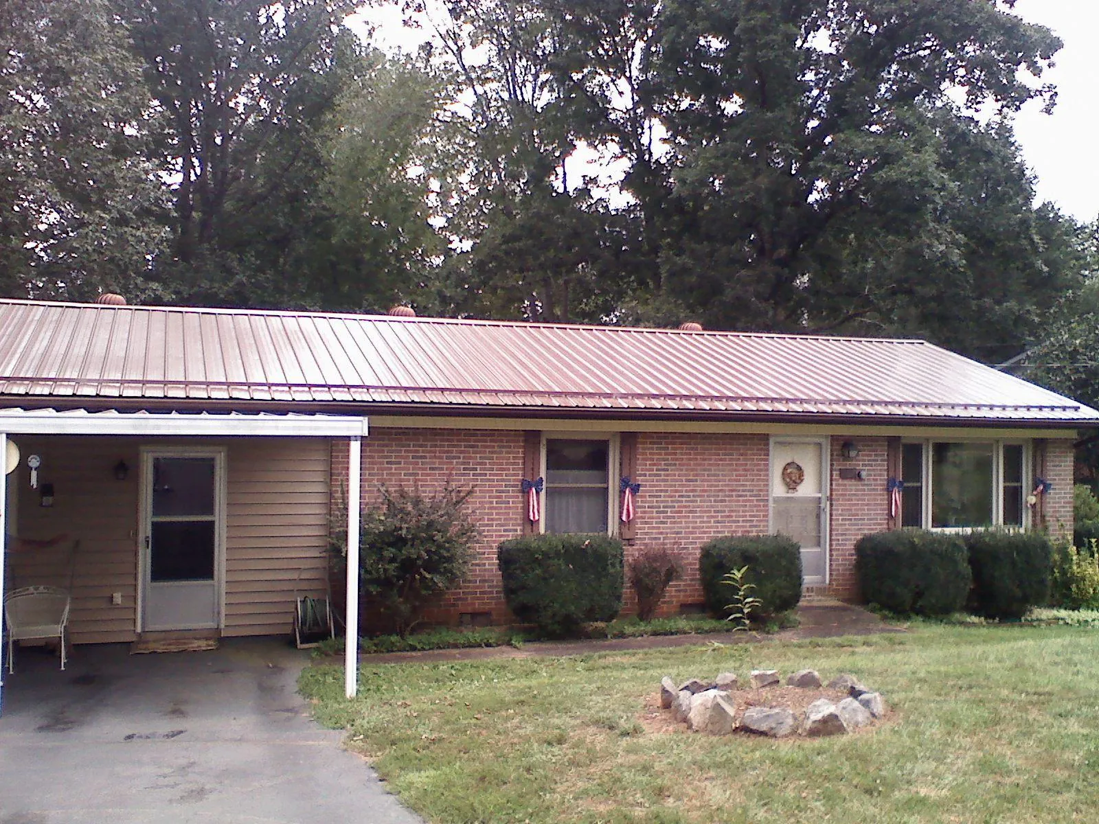 Bronze metal roof and carport on a brick ranch home — Roof Repair work by our crew in Prairieburg